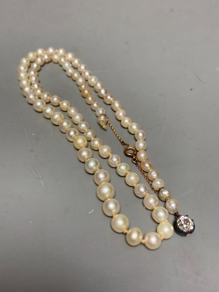 An early 20th century single strand graduated cultured? pearl necklace, with old cut diamond set white metal clasp, 42cm, gross weight 13.8 grams (string broken)